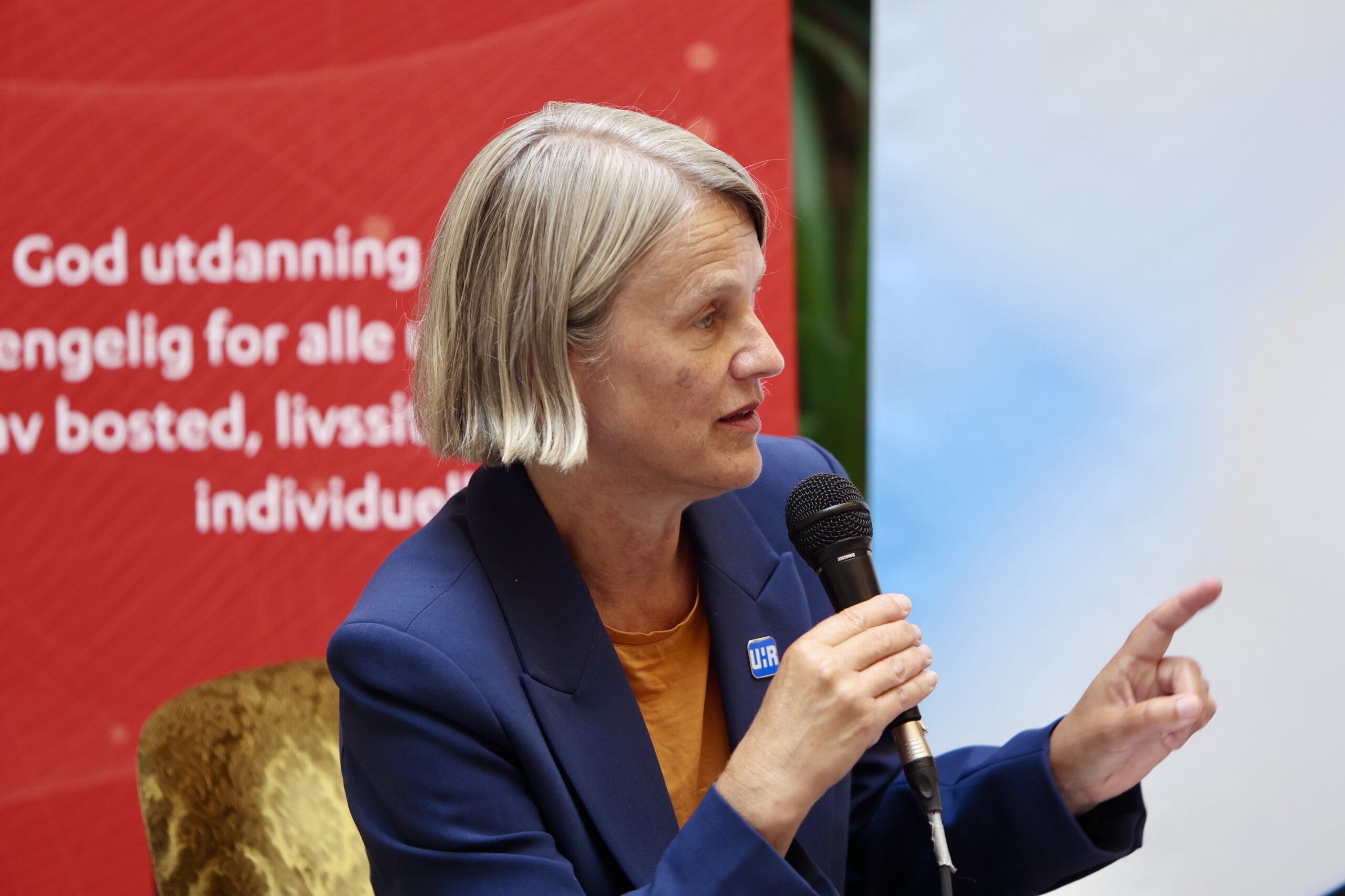 Bilder fra en paneldebatt på en scene med ordstyrer og fire paneldeltakere